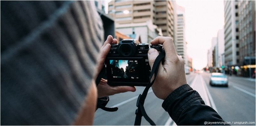 Ein Mann fotografiert eine Stadtstraße