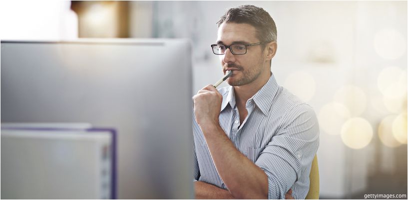 Mann in Brille vor einem Computermonitor