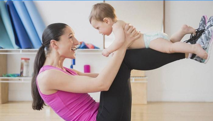 Das Mädchen ist mit einem Kind in Fitness beschäftigt