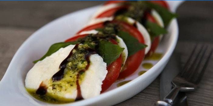 Caprese Salatgericht mit Pesto-Sauce auf einem Teller