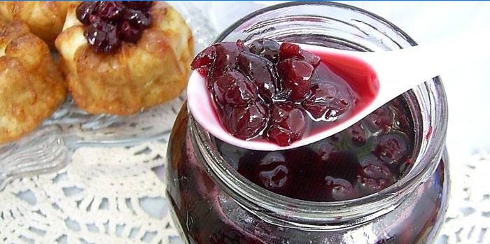 Kirschmarmelade in einem Glas und Gebäck