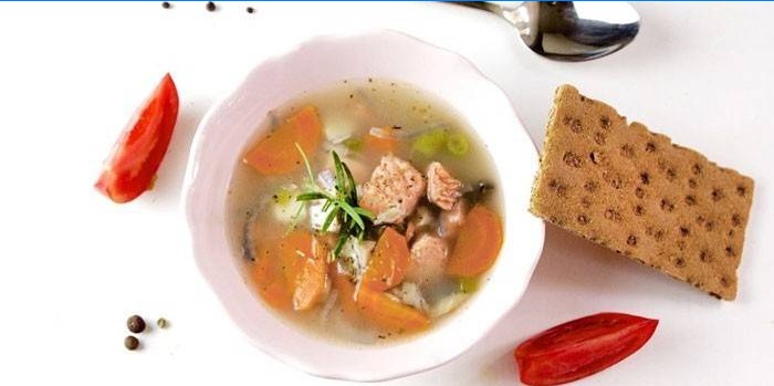 Lachssuppe in einem Teller und Brot