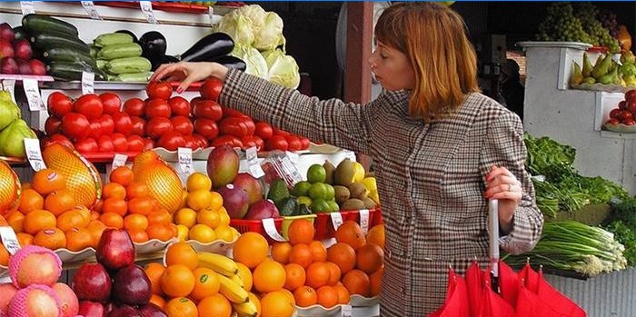 Mädchen wählt Gemüse auf dem Markt