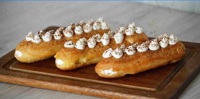 Eclairs mit Schlagsahnefüllung auf einem Schneidebrett