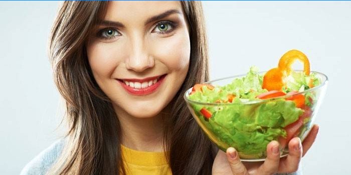 Mädchen hält einen Teller mit Salat in der Hand