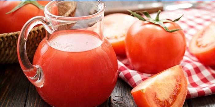 Tomatensaft in einem Krug und Tomate