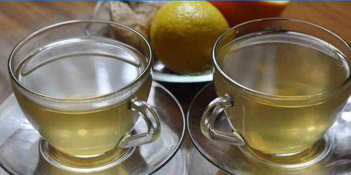 Zwei Tassen grüner Tee mit Ingwer und Orange.