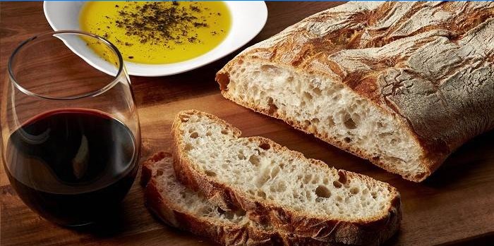 Ciabatta, ein Glas Wein und Olivenöl mit Gewürzen