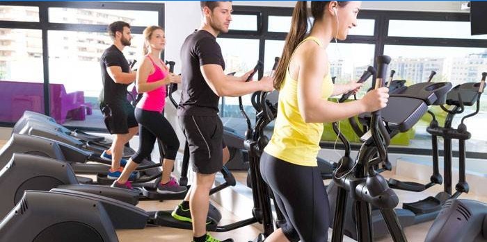 Die Leute machen Ellipsoide im Fitnessstudio