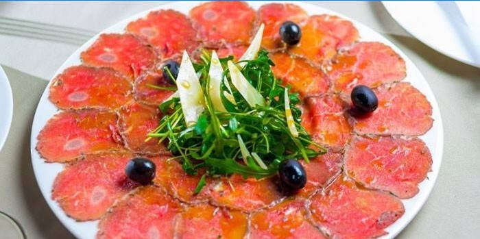 Gericht mit Kalbscarpaccio, Parmesan und Rucola