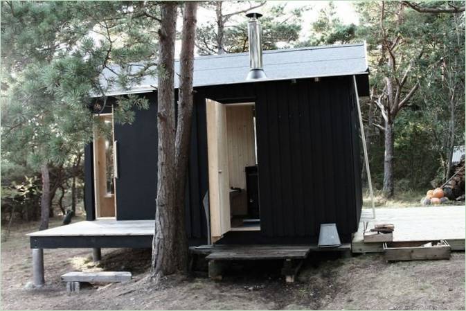 Holzhaus aus dem Pariser Studio Septembre in malerischer Umgebung mit Natur im Hintergrund, Trossö, Schweden